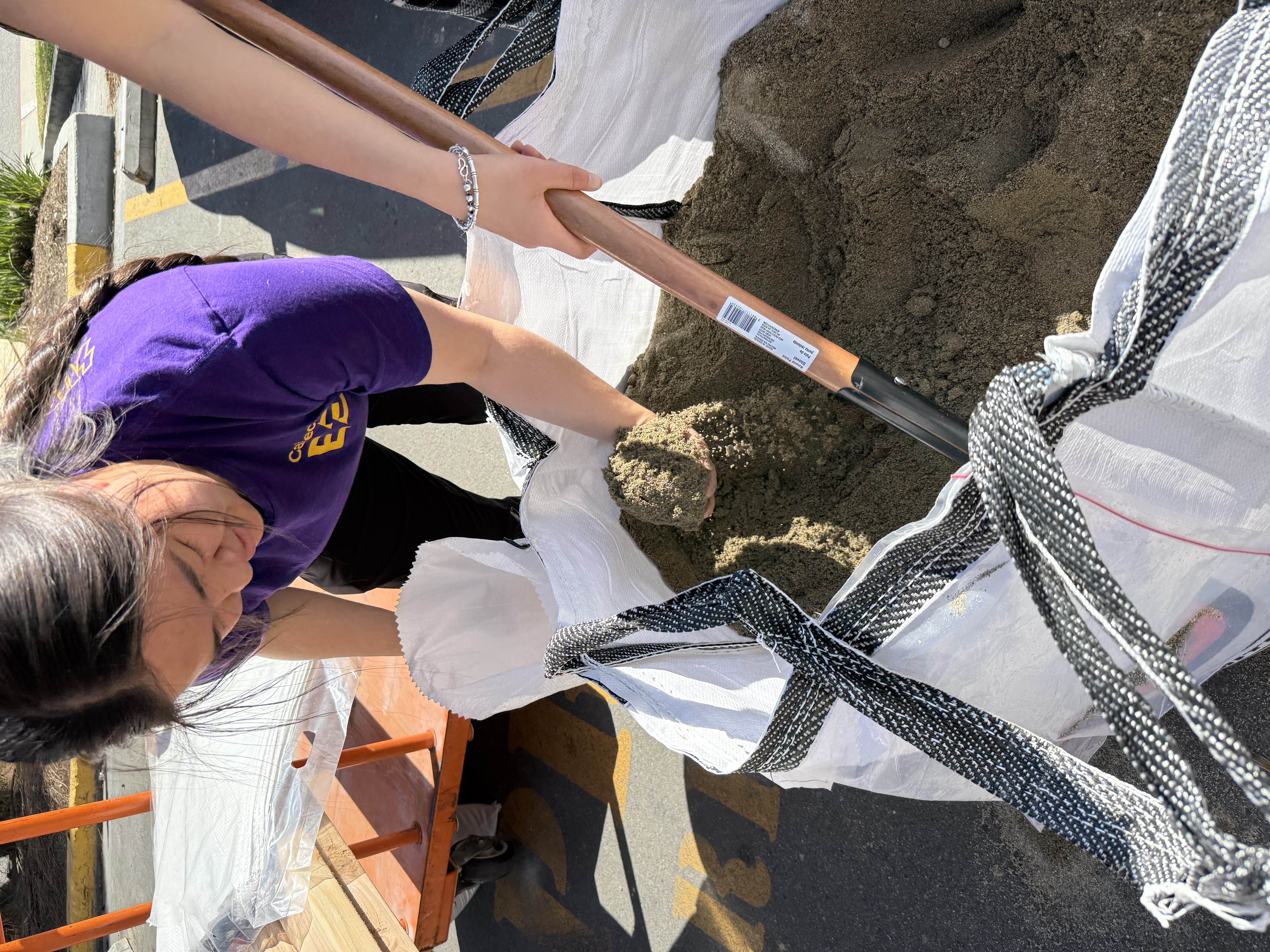 scooping sandbags with jit-bought shovels in the home depot parking lot
